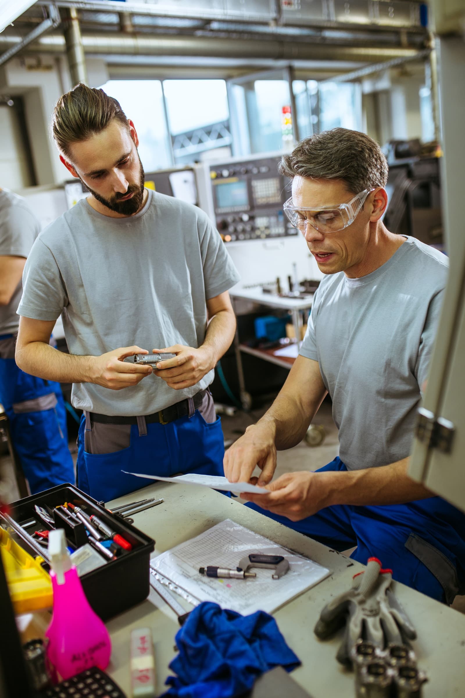 Zwei Handwerker prüfen gemeinsam ein Werkstück in der Werkstatt